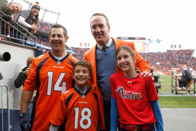 Denver, Colorado, 31. října, Brandon Stokely, Peyton Manning, Marshall Manning a Mosley Manning pózují pro fotografie během ceremonie uvedení do kruhu cti v poločase ze zápasu mezi washingtonským fotbalovým týmem a denver broncos na empower field na míli vysoko 31. října 2021 v denveru, colorado foto: justin edmondsgetty snímky