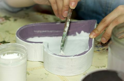 ruce malování uvnitř fialové dřevěné srdce ve tvaru bílé krabice