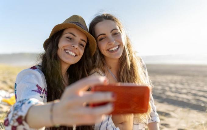 dva nejlepší přátelé, kteří si fotí selfie s chytrým telefonem na pláži