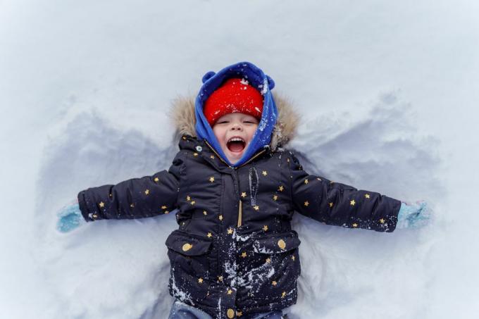 malé dítě ve sněhu dělat sníh anděl