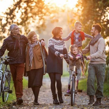 usměvavá vícegenerační rodina na procházce s koly v přírodě a užívající si společný čas
